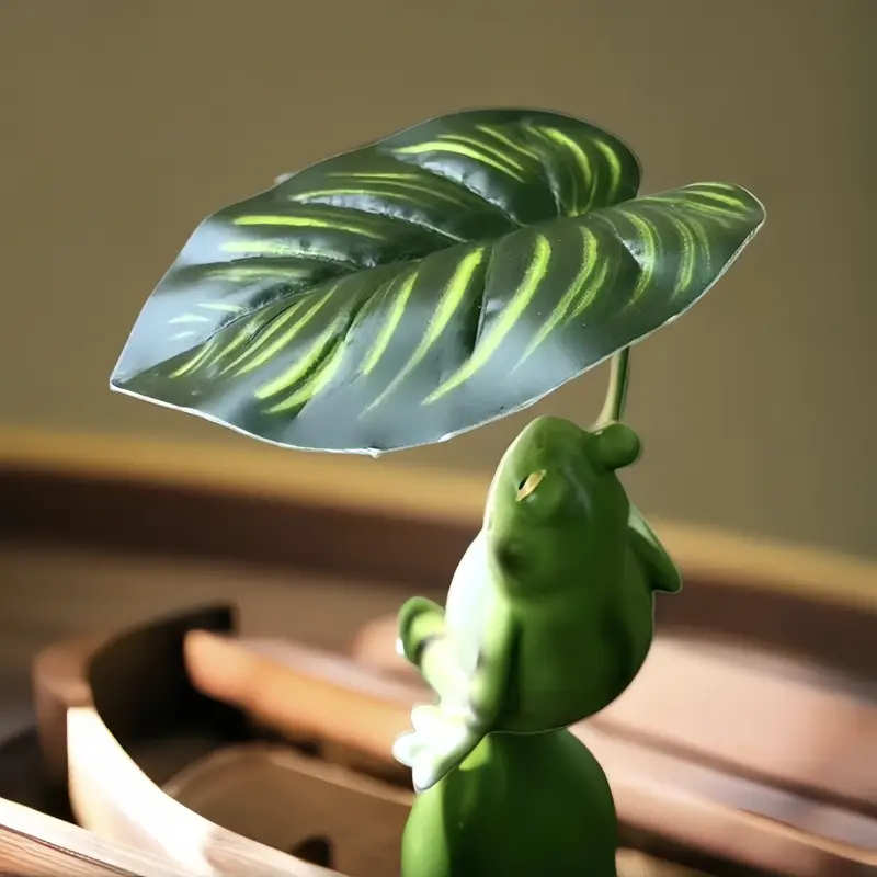 Sapo encantador segurando uma folha